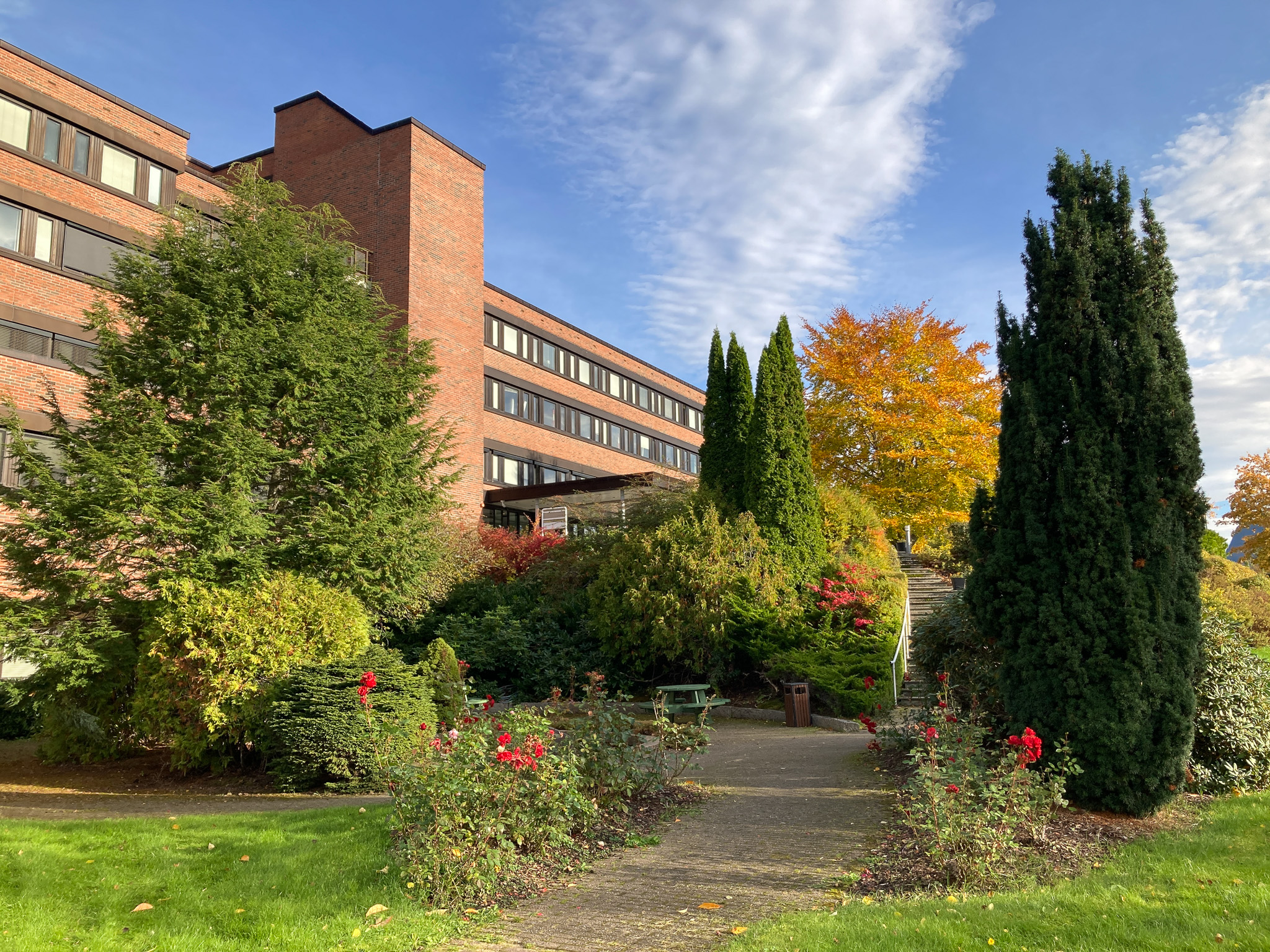 En bygning med trær og busker foran seg